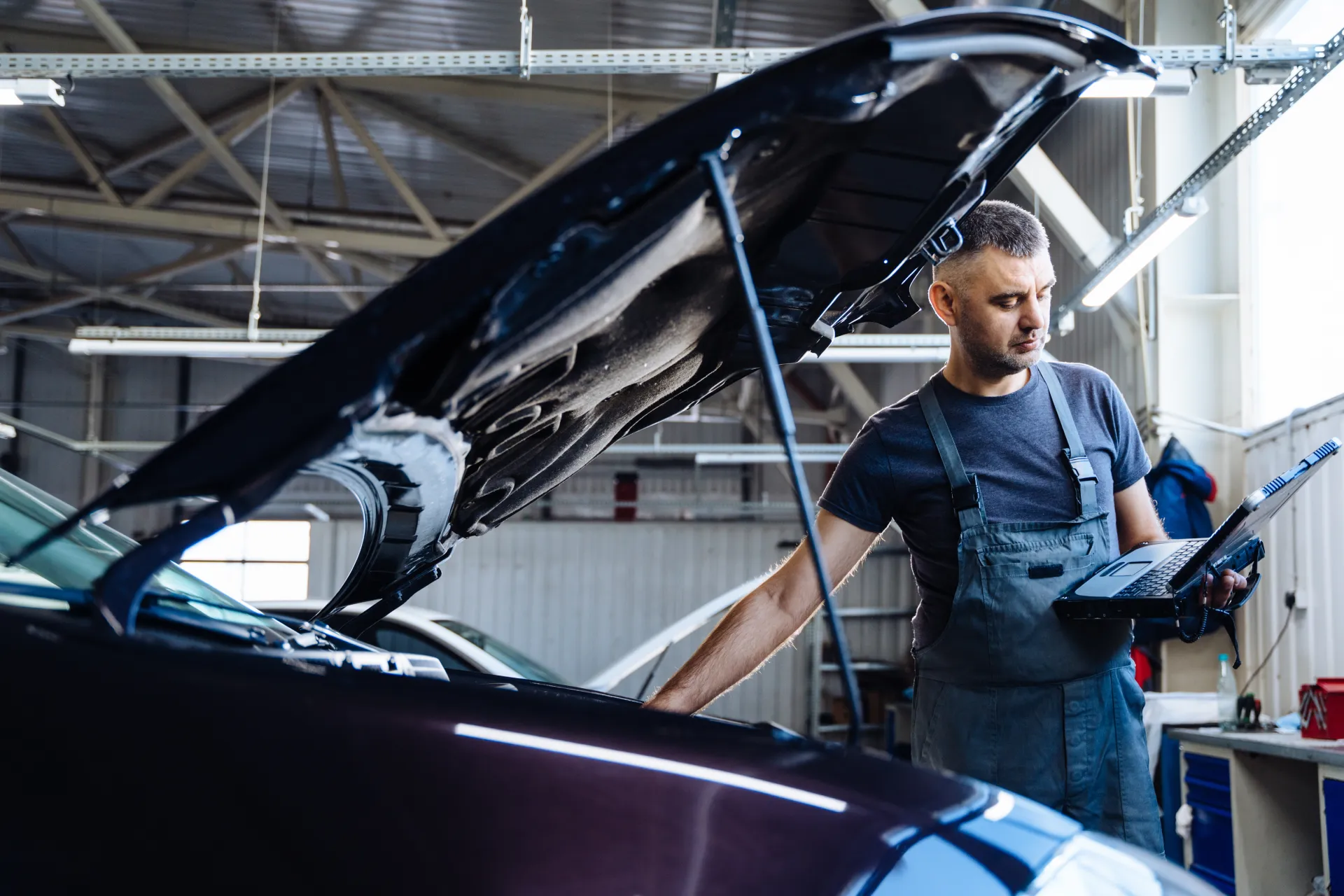 Mécanicien vérifiant un moteur avec un ordinateur